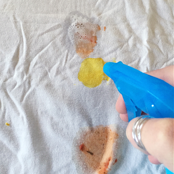 Applying homemade stain remover to a variety of stains on a shirt