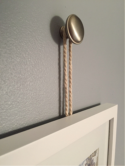 Picture frame hanging from a drawer knob with rope