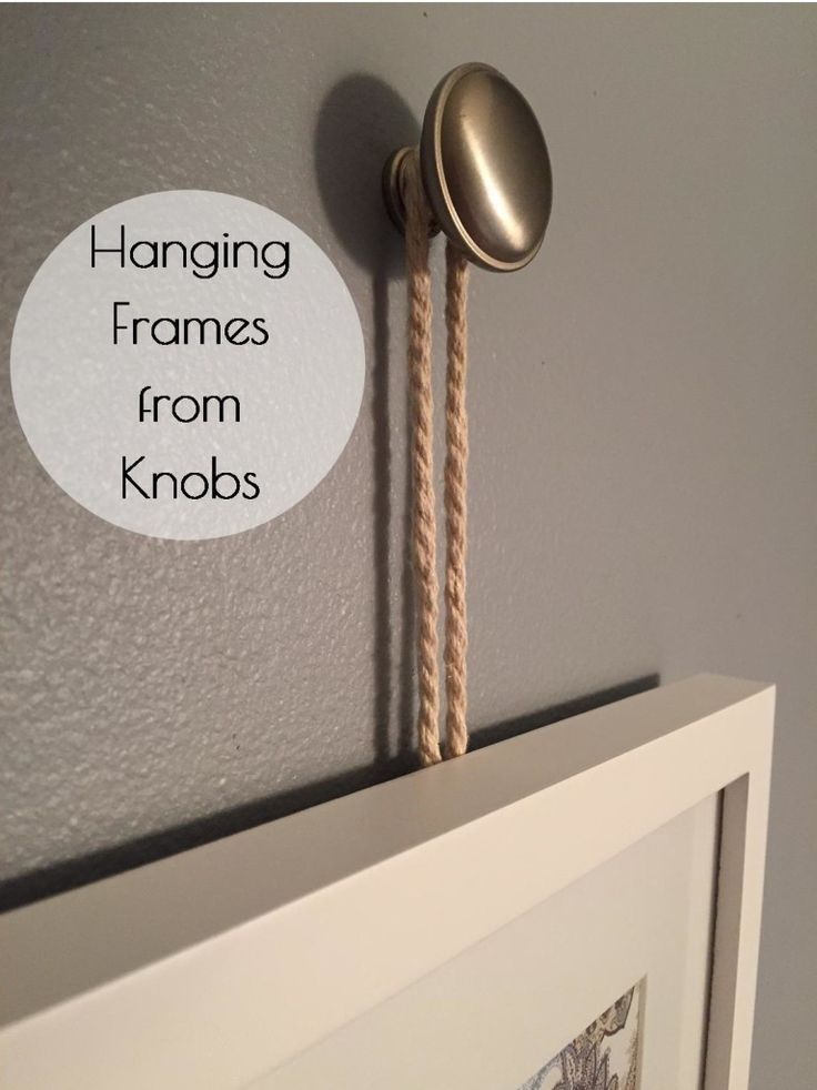 A framed print hanging from a knob with twine