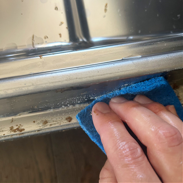 Cleaning dishwasher door with scour pad and dish soap