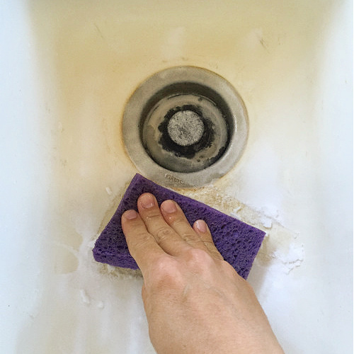 Scrubbing porcelain sink with baking soda