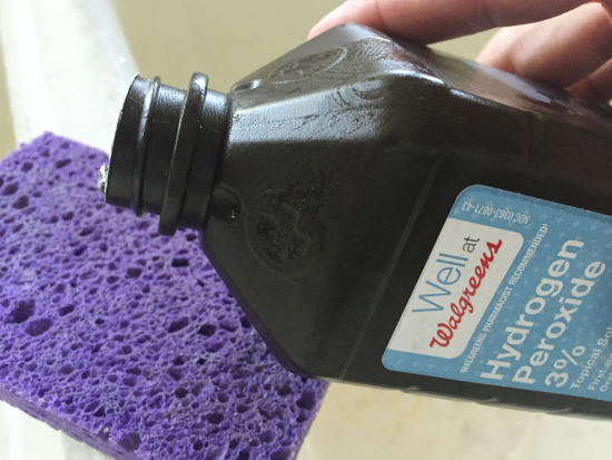 Adding a small amount of hydrogen peroxide to a sponge in order to clean a porcelain sink