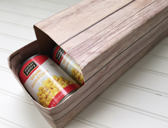 Soda box wrapped in wood print paper used to store canned goods