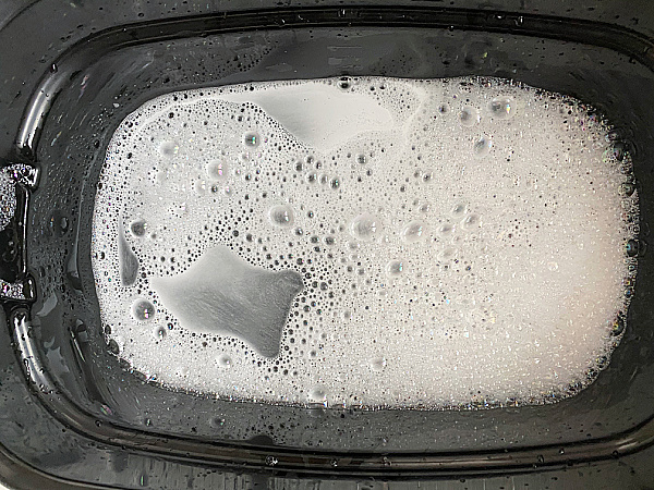 Combining Sal Suds mixture with water to make floor cleaner in a cleaning bucket