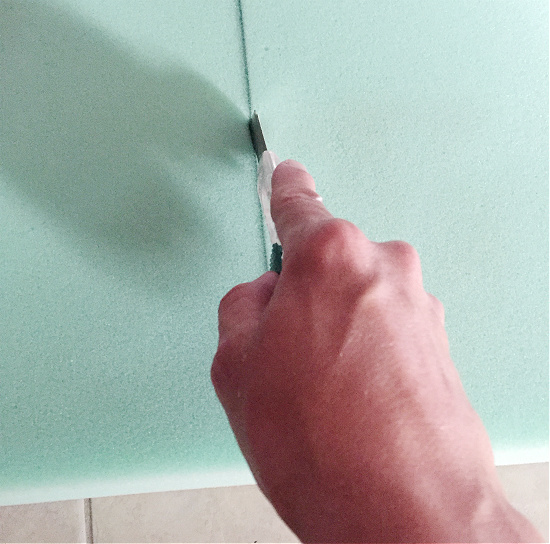 Cutting foam with razor to make a bench cushion