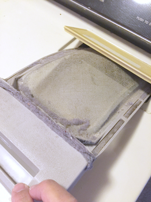 Removing lint filter from dryer for cleaning.