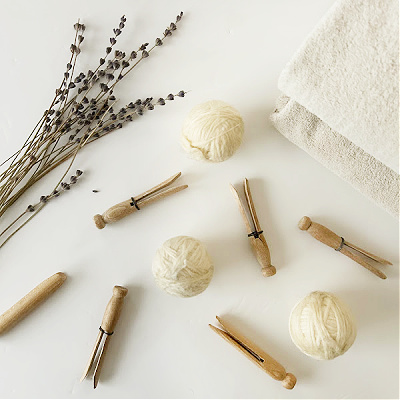 DIY Dryer Balls sitting amongst vintage clothespins and lavender