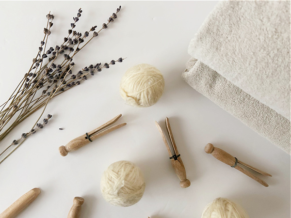 DIY Dryer Balls sitting amongst vintage clothespins and lavender