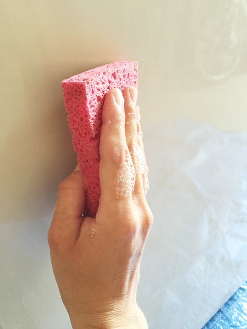 Using wet soapy sponge to clean appliance prior to painting