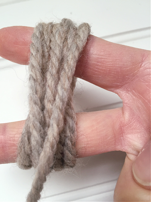 Wrapping yarn around fingers to make dryer balls