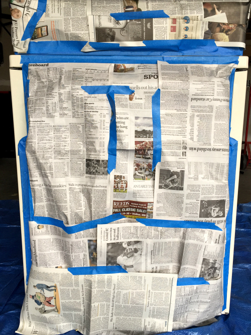 Dryer back taped with newspaper to avoid painting back of appliance