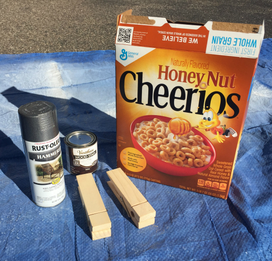 Items needed to make a DIY Lint Box: large cereal box, spray paint, jumbo clothespins and wood staind