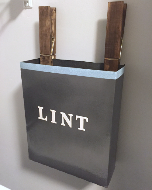 DIY Lint box hanging from jumbo clothespins on wall