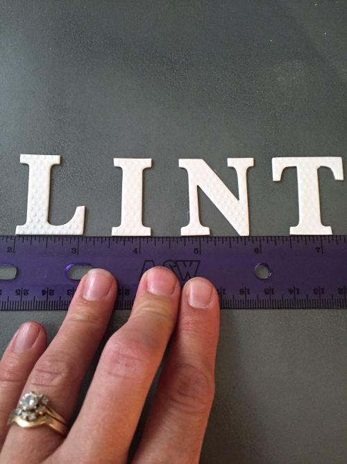 Spelling LINT with white letters on a DIY Lint Box