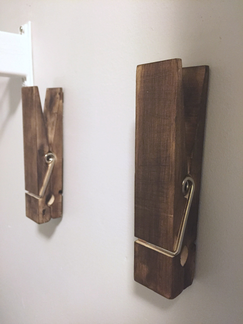 Jumbo clothespins secured to wall with command strips