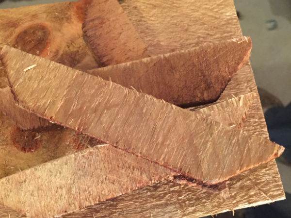 Tops of cedar fence posts that have been cut off so planks can be used to make a wood shelf overlay to cover a wire shelf