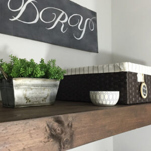 Styled faux wood shelf used to hide wire shelving in laundry room