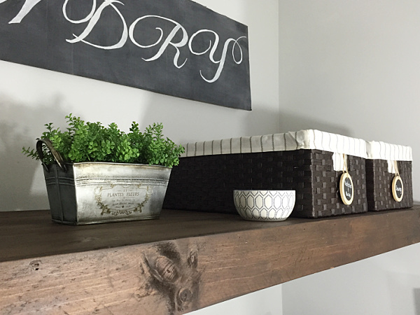 Styled faux wood shelf used to hide wire shelving in laundry room