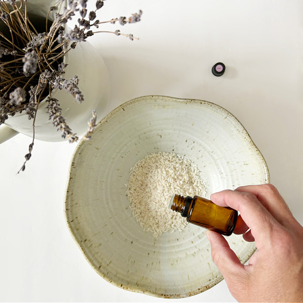 Adding essential oil to dried rice as a DIY sachet filling