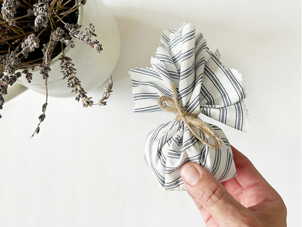 DIY Sachet made with rice, essential oil, and dried lavender wrapped in ticking stripe fabric