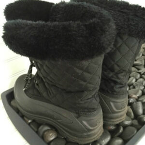Boots sitting in boot tray filled with black river rock