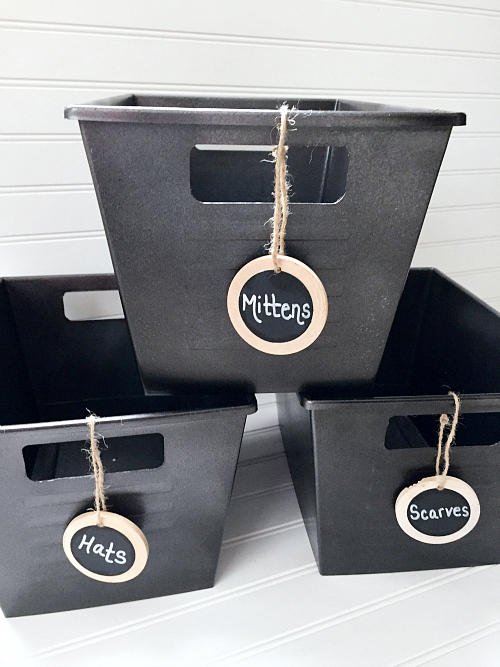 Bright colored dollar store bins after makeover with spray paint to create a faux metal look. Wooden Chalkboard labels attached to handles.