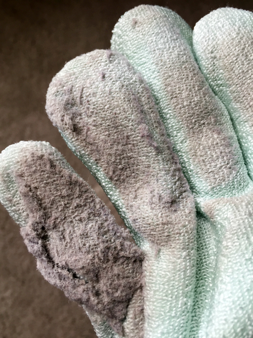 Microfiber dusting mitt full of dust after cleaning wood blinds