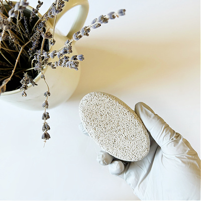 Gloved hand holding pumice stone