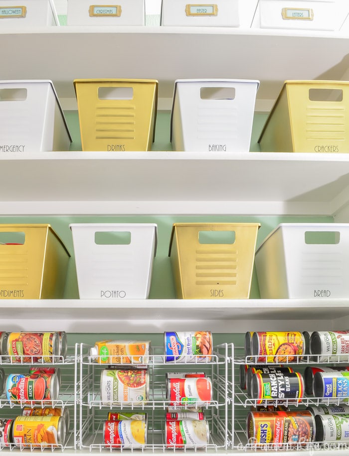 Dollar store bins being used in a pantry after a makeover with white and gold paint