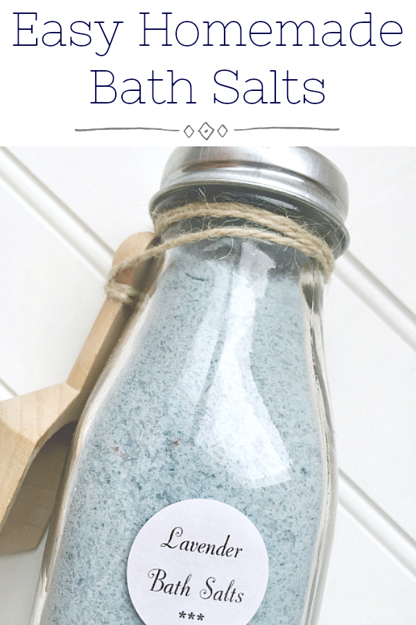 Easy Recipe for DIY Bath Salts. Pinterest image showing lavender bath salts in a glass milk jar with a small wooden scoop attached with twine.
