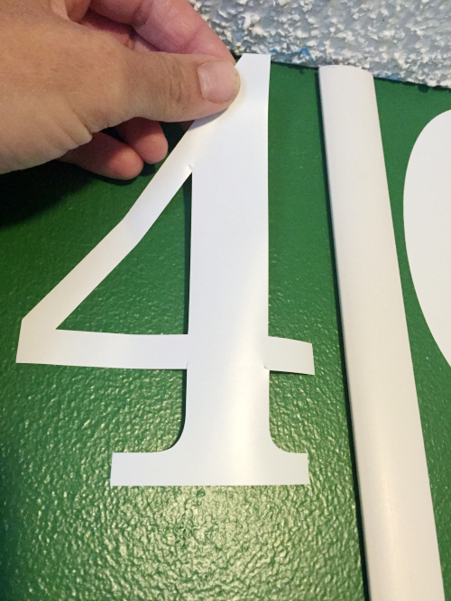 Adhering vinyl decals to football field wall