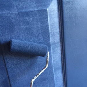 Using paint roller to paint front door blue