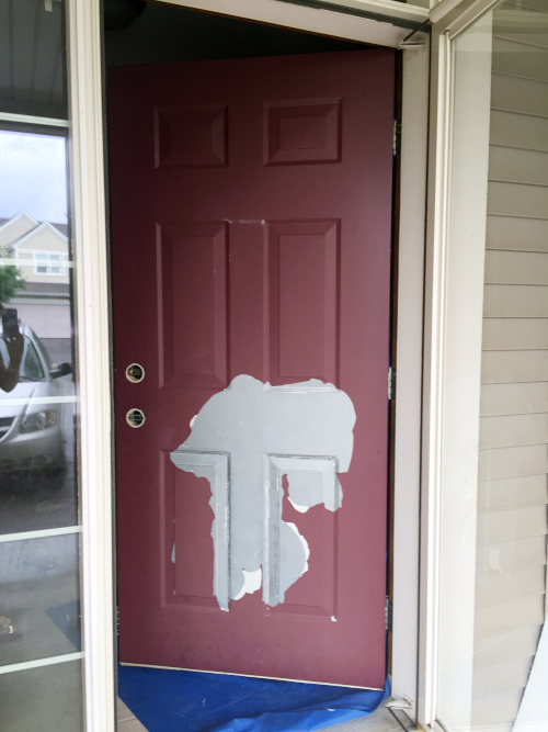 Red front door with lots of peeling paint