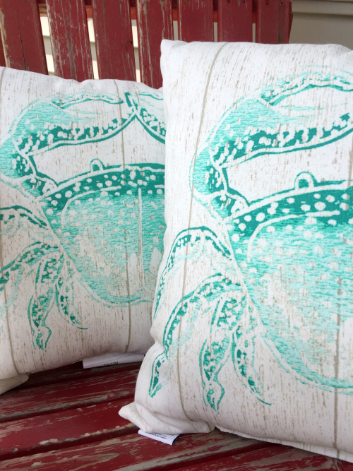 Outdoor throw pillows featuring blue crabs on the fronts