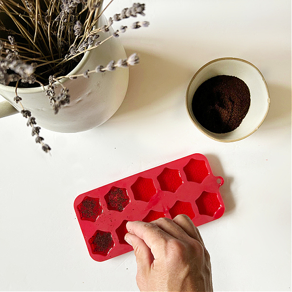 Sprinkling fresh coffee grounds on top of DIY Wax Melts