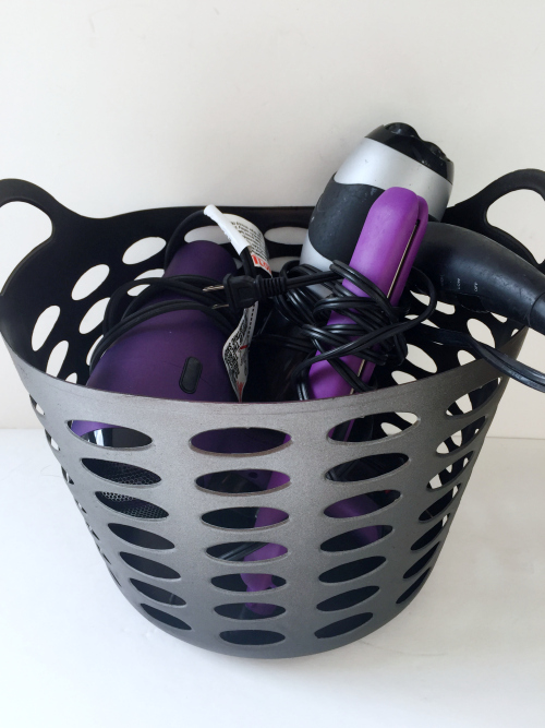 Dollar store basket, spray painted and used to store hair dryers and flat iron