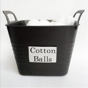 Spray painted dollar store bin filled with cotton balls