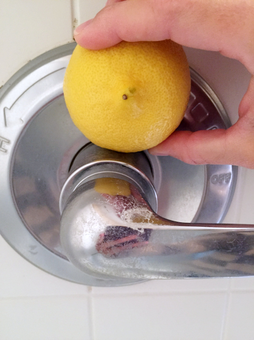 Trying a sliced lemon to remove scum from shower handle