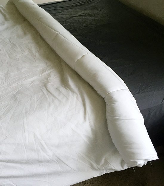 Rolling duvet cover and comforter together starting at the top of the bed.