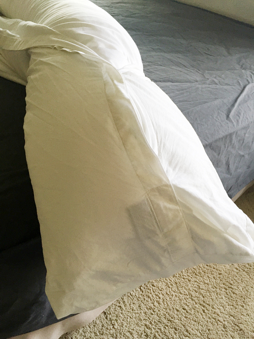 Tucking rolled comforter into the duvet cover and closing it up with the closure.