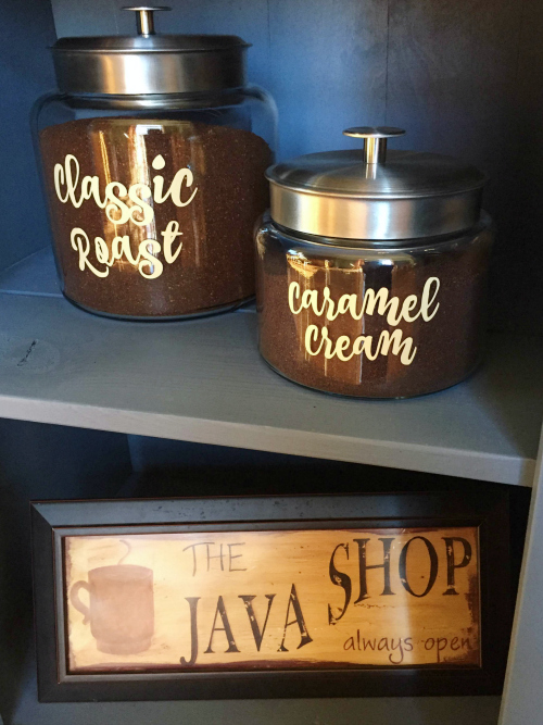 Glass jars filled with ground coffee and labeled with vinyl lettering