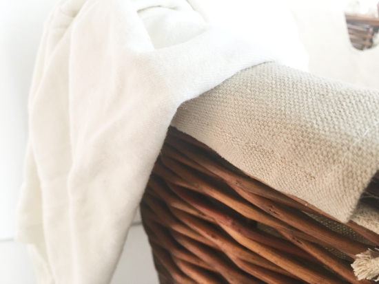 T-shirt hanging over the side of a wicker laundry basket