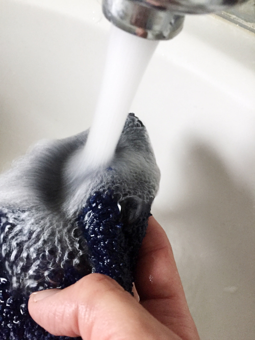 Wetting down washcloth to remove wrinkles from clothes