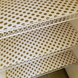 Foam board wrapped in wrapping paper to create shelf to hide wire shelving in linen closet