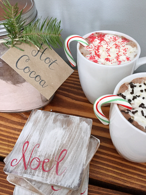 Several mugs of hot cocoa displayed with DIY wood coasters