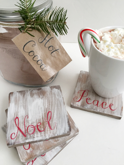 Mug of hot cocoa on a white washed wooden coasters