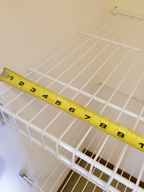 Using measuring tape to measure wire shelving