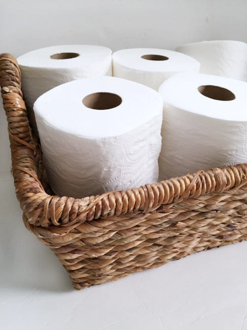 Close up of toilet paper in a wicker bin