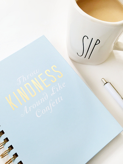 Spiral notebook next to a mug of coffee