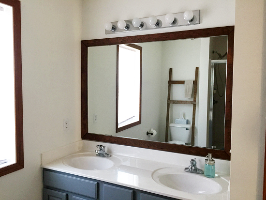 Builder-grade bathroom mirror framed with a DIY barn wood frame